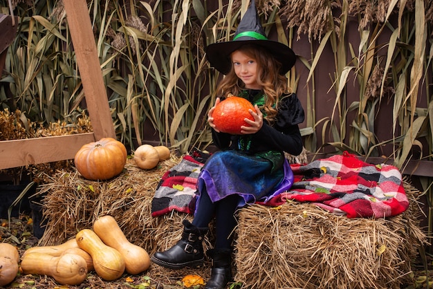 bambina vestita da strega con una zucca festeggia halloween