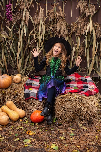 bambina vestita da strega con una zucca festeggia halloween