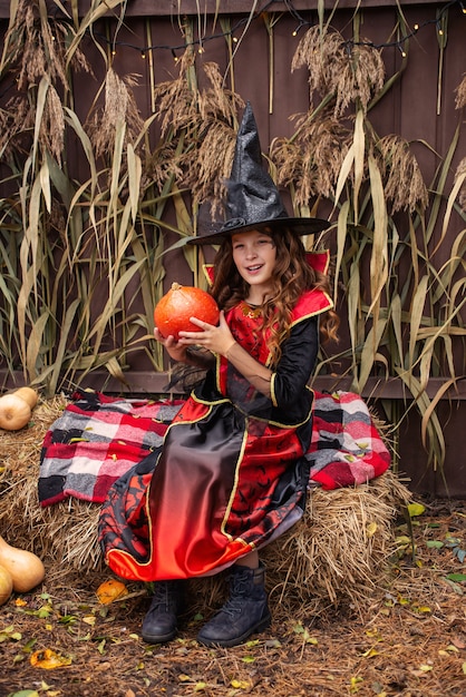 bambina vestita da strega con una zucca festeggia halloween