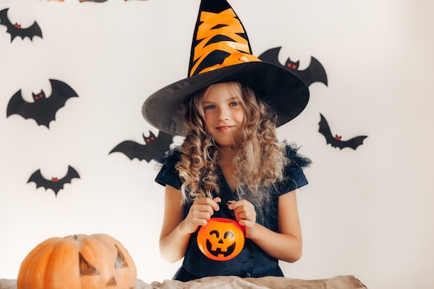 Bambina vestita da strega con una zucca. Halloween. zucca per halloween