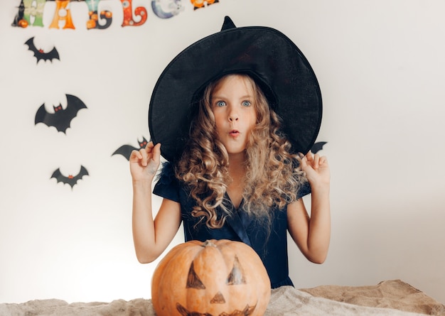 Bambina vestita da strega con una zucca. Halloween. zucca per halloween