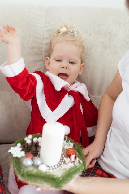 Bambina vestita in abito natalizio con impianti cocleari divertendosi a casa diversità e apparecchi acustici e tecnologie innovative per il trattamento della sordità Copia spazio e luogo per la pubblicità