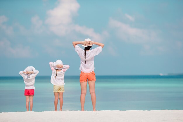 Bambine adorabili e giovane madre sulla spiaggia bianca tropicale