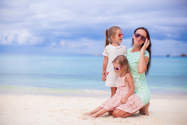 Bambine adorabili e giovane madre sulla spiaggia bianca tropicale