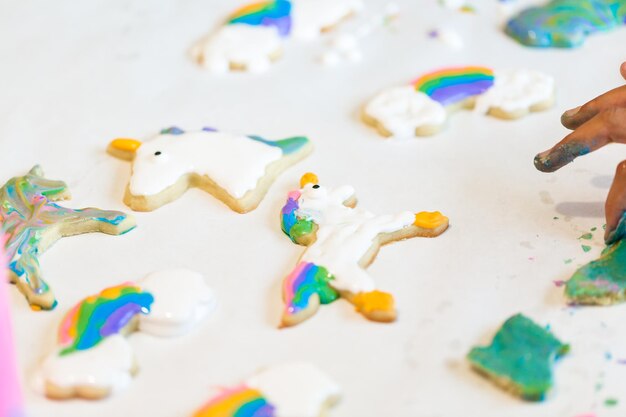 Bambine che fanno biscotti di unicorno alla data di gioco.