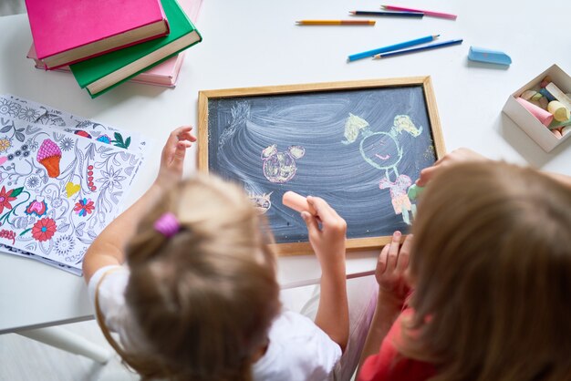 Bambine che giocano con la lavagna