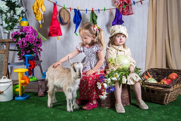 Bambine che giocano con le capre in terreni agricoli