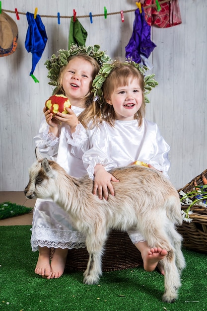 Bambine che giocano con le capre in terreni agricoli