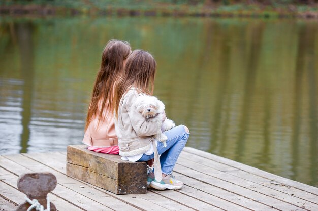 Bambine con un cucciolo bianco. Un cucciolo nelle mani di una ragazza