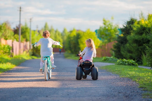 Bambine felici che ciclano all'aperto al parco