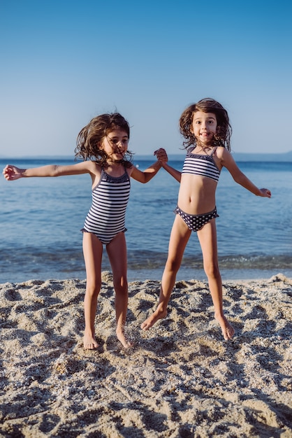 Bambine sveglie divertendosi sulla spiaggia