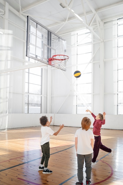 Bambini a tutto campo che giocano a basket