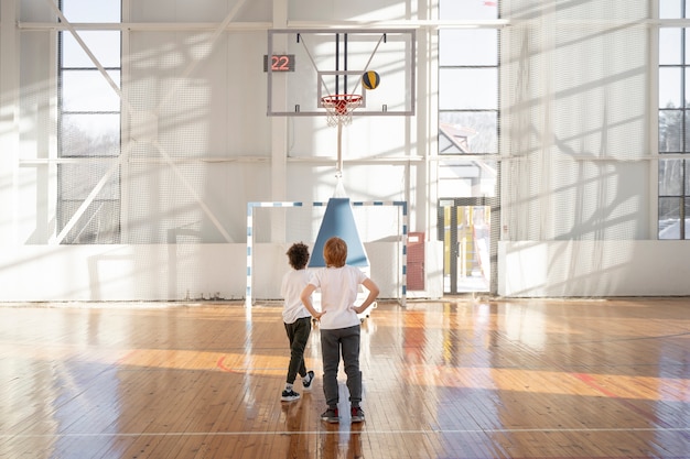 Bambini a tutto campo che giocano a basket