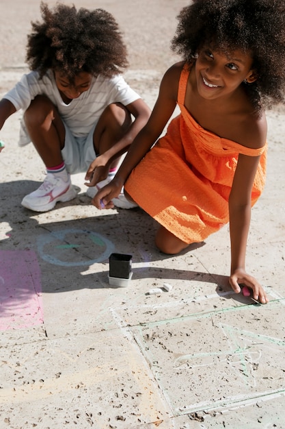 Bambini ad alto angolo che disegnano sul marciapiede