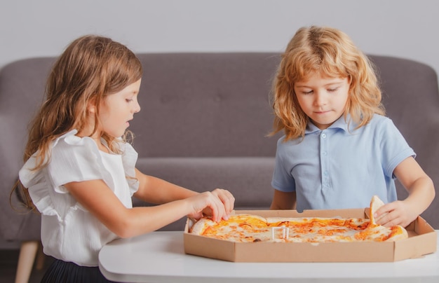 Bambini affamati che mangiano pizza I bambini si preparano a mangiare la pizza fresca.