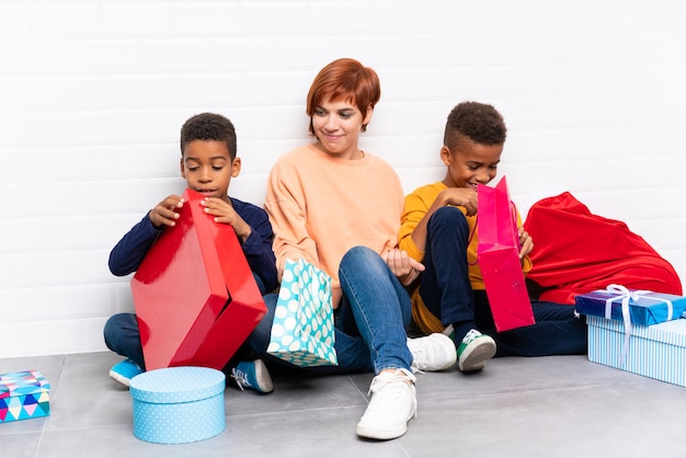 Bambini afroamericani con la madre tra i tanti regali per le vacanze di Natale