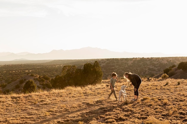 Bambini al tramonto che giocano con il loro Golden Retreiver crema inglese