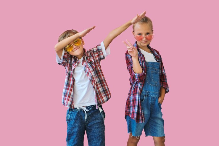 Bambini alla moda svegli in occhiali da sole a colori che guarda l'obbiettivo a