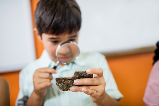 Bambini alla ricerca di fossili con una lente d'ingrandimento