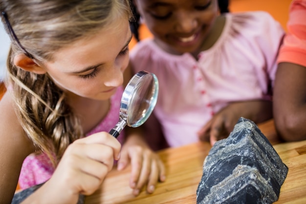 Bambini alla ricerca di fossili con una lente d'ingrandimento