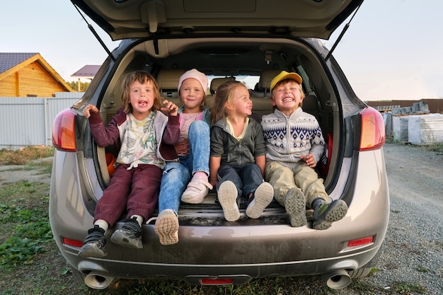 Bambini allegri che si divertono nel bagagliaio dell'auto