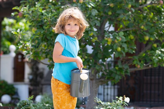 Bambini americani infanzia bambino che innaffia i fiori nel giardinaggio domestico del giardino