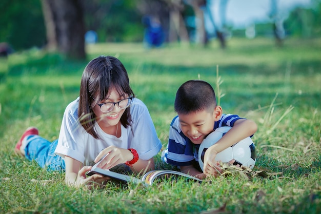 bambini asiatici, leggendo il libro nel parco