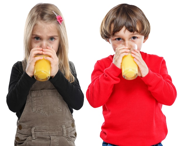 Bambini bambini che bevono succo d'arancia mangiare sano formato ritratto isolato su bianco