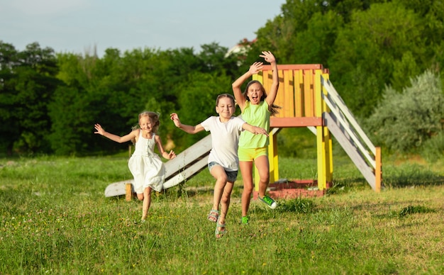 Bambini, bambini che corrono sul prato alla luce del sole d'estate