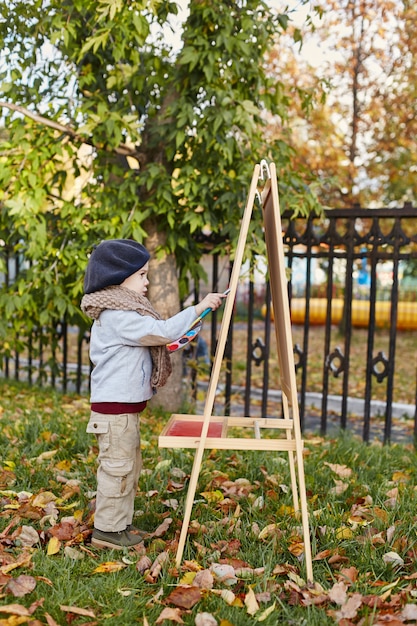 Bambini bambino in abiti primavera autunno retrò. Sorridere di seduta del piccolo bambino in natura, sciarpa