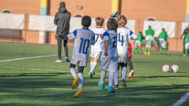 Bambini calcio calcio bambini giocatori che si esercitano prima della partita sul campo di calcio