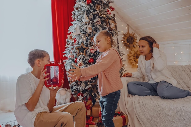 Bambini carini che incartano i regali di Natale primo piano Confezione regalo Famiglia vacanze invernali e concetto di persone