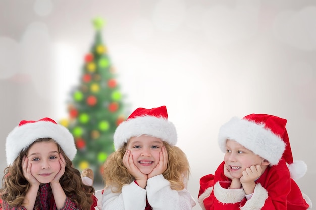 Bambini carini contro albero di Natale sfocato in camera