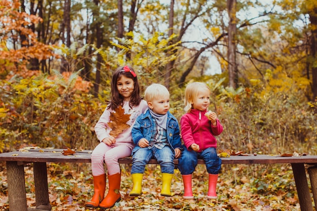 Bambini carini seduti sulla panchina dopo una lunga passeggiata nel parco. I bambini si riposano e si lanciano