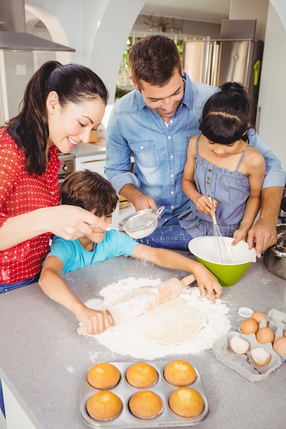 Bambini che aiutano i genitori a preparare il cibo