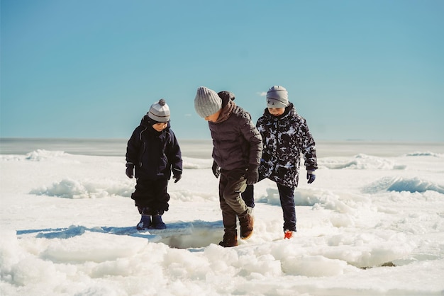 Bambini che camminano sulla spiaggia ghiacciata dell'immagine del golfo di Finlandia con il fuoco selettivo