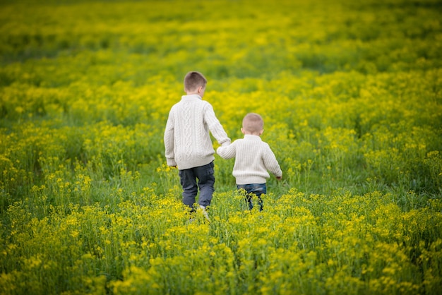 Bambini che corrono sul campo e si tengono per mano.