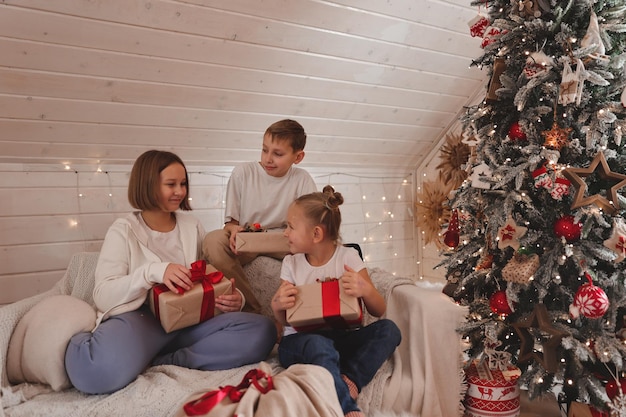 Bambini che decorano l'albero di Natale, Buon Natale e Vacanze di Capodanno. Famiglia, vacanze invernali e concetto di persone, famiglia amante del ritratto da vicino.