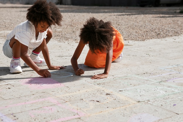 Bambini che disegnano sul marciapiede a tutto campo