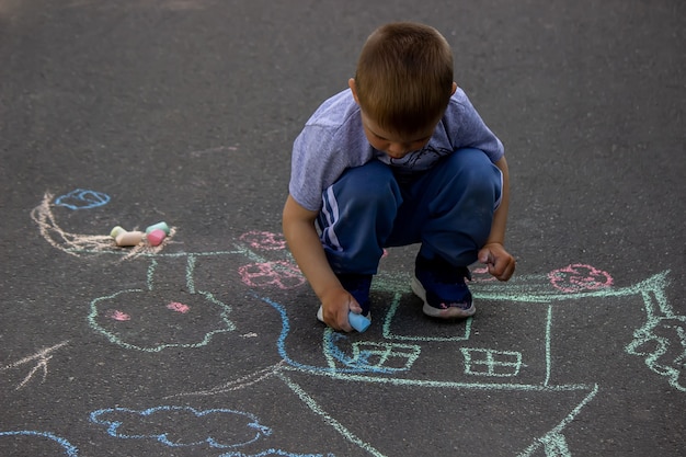 Bambini che disegnano sulla casa di famiglia dell'asfalto. Messa a fuoco selettiva