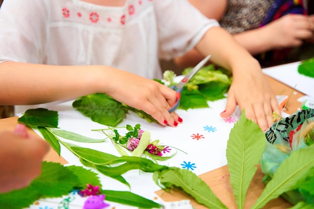 Bambini che fanno composizione di applique con fiori freschi