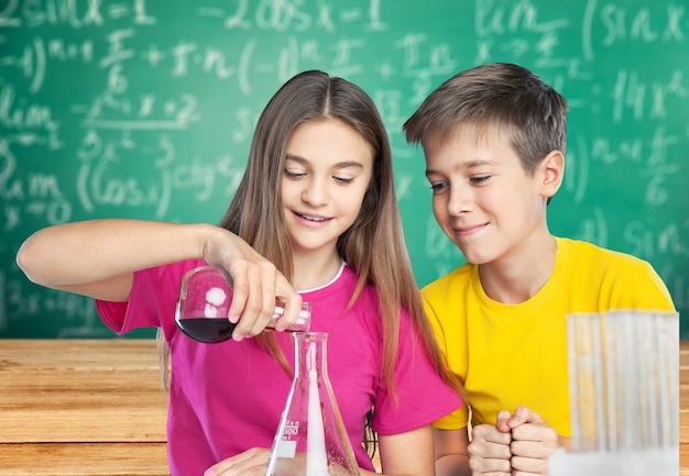 Bambini che fanno esperimenti chimici con tubi di vetro