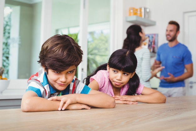 Bambini che fanno i volti seduti al tavolo