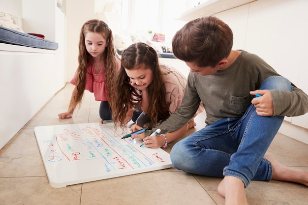 Bambini che fanno l'elenco delle faccende domestiche sulla lavagna a casa