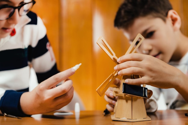 Bambini che giocano a costruire un modello di mulino a vento solare Giocattolo generico senza marchio