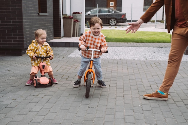 Bambini che giocano a gareggiare in bici e scooter all'aperto