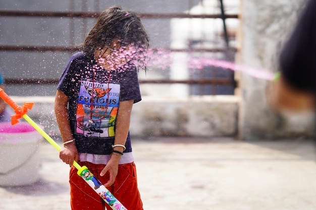 Bambini che giocano a holi con acqua e colori