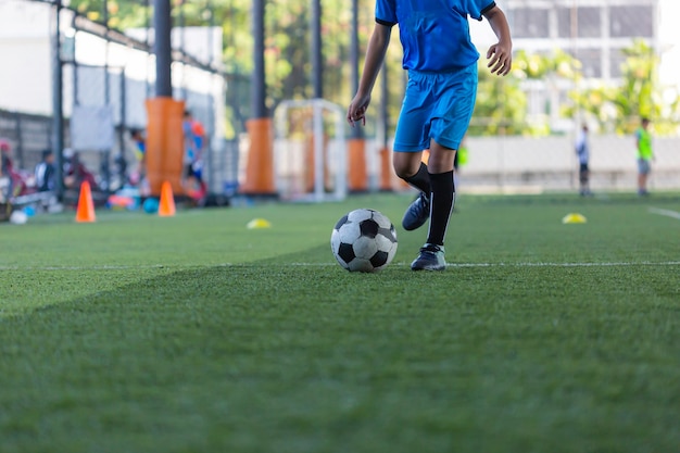 Bambini che giocano a tattiche di controllo del pallone da calcio sul campo in erba con sfondo di allenamento Formazione dei bambini nel calcio