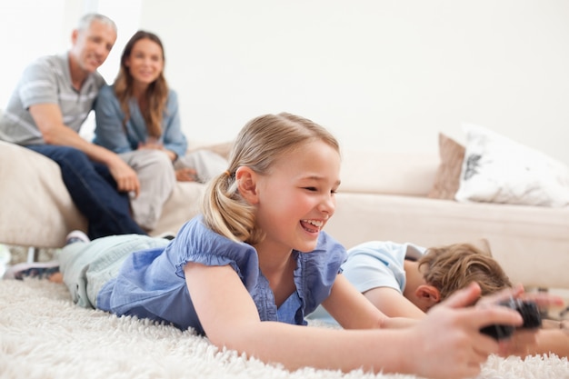 Bambini che giocano ai videogiochi con i loro genitori sullo sfondo