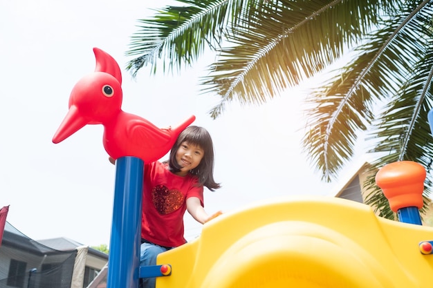 Bambini che giocano al parco giochi ragazza felice